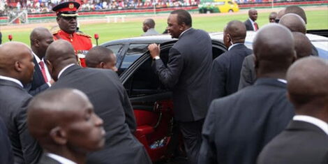 Former President Uhuru Kenyatta surrounded by his security detail at a past national holiday event.