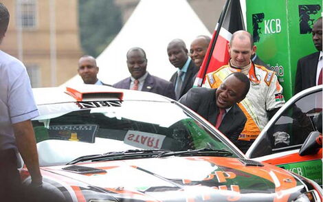 President Uhuru Kenyatta enters a rally car driven by Ian Dancun during the KCB Safari Rally flagging off ceremony at KICC Nairobi, on September 21, 2014.