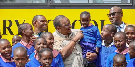 Former President Uhuru Kenyatta poses for a photo with Partakilat Primary school children on Saturday, October 15, in Narok.