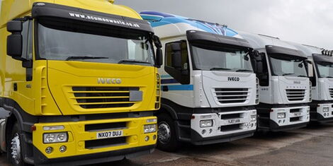 An image of second hand trucks in a yard.