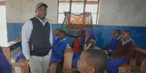 A screen grab image of Daniel Zuma (center) speaking to school children in his community.