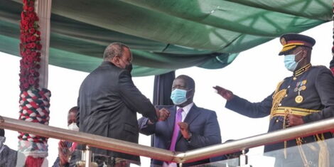 President Uhuru Kenyatta greeting Interior CS Fred Matiang'i during Mashujaa Day celebrations held at Wang'uru stadium in Kirinyaga County on October 20, 2021.