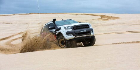  A Toyota Hilux cruising a dusty terrain. 