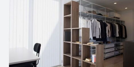 An image of a shelf divider with a background of lined clothes