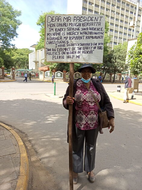 Former Kamukunji Parliamentary aspirant Mercy Wanjiru Mwangi holds a placard near Office of the President building in Nairobi.