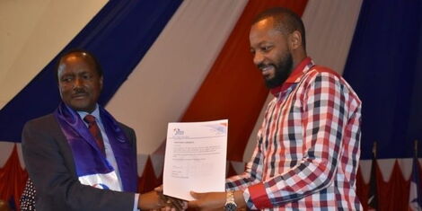 Wiper Democratic Movement Party Leader Kalonzo Musyoka (left) presents Ben Mulwa with his nomination certificate at the Bomas of Kenya on April 6, 2022