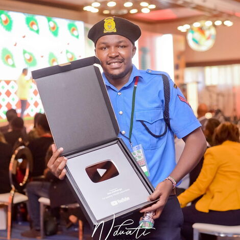 Comedian Alex Mathenge receiving an accolade from YouTube