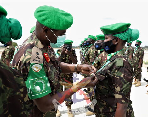 A KDF soldier receiving her medal from an AMISOM official in Somalia on October 26, 2021, 