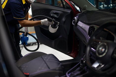 File photo of an attendant cleaning the interior of a car
