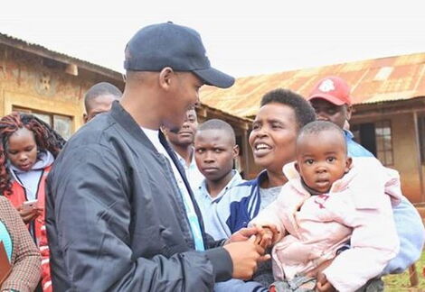 Politician Allan Chesang interacting with a resident on June 2018.