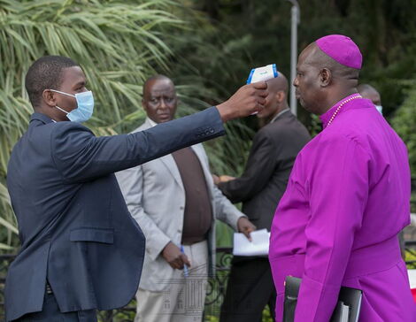 A health officer screens a clergyman for a rise in temperature at StateHouse, Nairobi on Saturday, March 21, 2020.