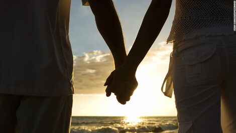 A stock photo of a couple holding hands.