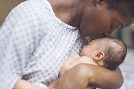 Image of a mother caressing her newborn baby