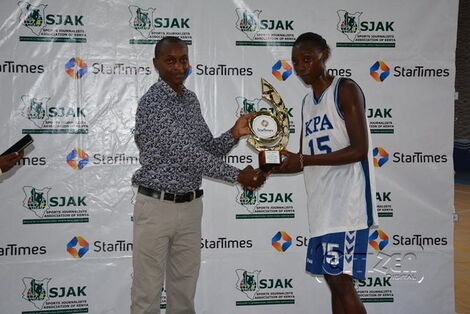 Felmas Adhiambo Koranga being awarded the Most Valuable Player trophy by StarTimes Public Relations Manager, Alex Mwaura, at Makande Gymnasium in Mombasa on March 28, 2018.jpg