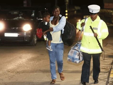 Amina Ramadhan, a police officer from Embakasi assisting an overwhelmed mother who was stranded on the first night of the curfew on March 27.