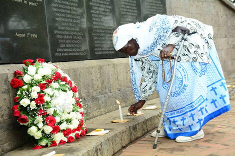     Margaret Achieng, who lost her daughter in the bombing of the US embassy in Nairobi on August 7, 1998, was seen lighting a candle in Memorial Park on August 7. 