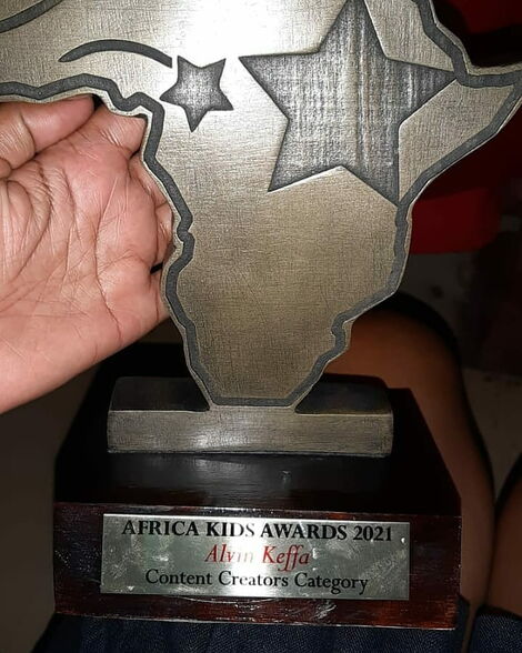 Alvine Keffa holding his award con May 23