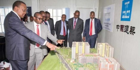 Former President Uhuru Kenyatta (left) together with Transport & Infrastructure PS Charles Hinga (second left) viewing a model of houses to be constructed at Park Road Estate in Ngara under the Affordable Housing Pillar of the Big 4 Agenda in May 2019.