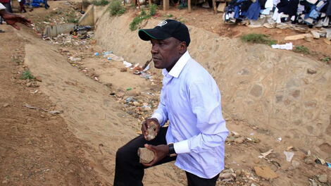 Former Kakamega Senator Boni Khalwale carries stones to defend himself in Kibera on November 7, 2019 during Kibra By-elections.