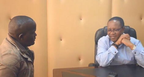  Interior Principal Secretary Karanja Kibicho (right) speaks to city hawker Dennis Wachira at Harambee Offices in 2018. 