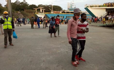 A resident helps another following the stampede at Likoni Ferry Channel on July 21, 2020.