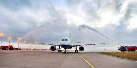 An image of an aero plane being given a water salute.