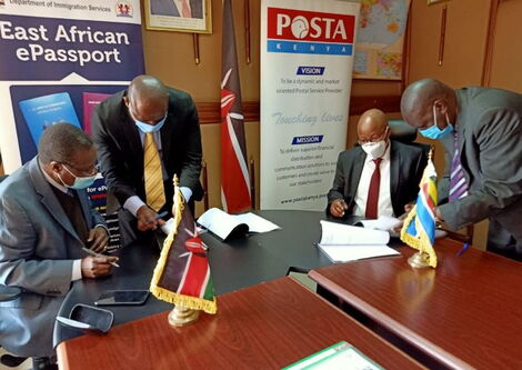 Post Master General Dan Kagwe and Director General Immigration Department Alexander Muteshi signing an MOU on July 30, 2020.