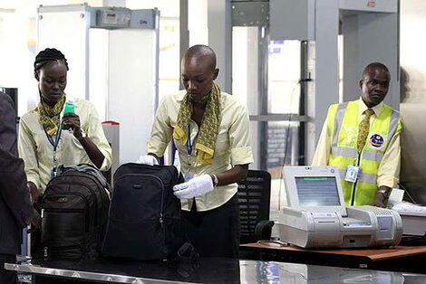 Screening officers frisking luggage at an airport in Kenya