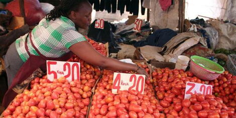 A woman selling tomatoes at a market in Kenya
