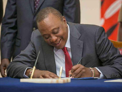 President Uhuru Kenyatta siging a Bill into law at State House in Nairobi, October 13, 2017.