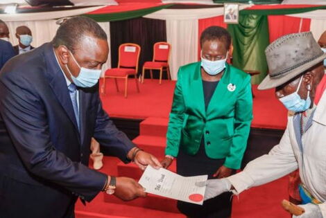 President Uhuru Kenyatta presenting land title deeds to a section of beneficiaries of the National Land Titling Program at KICC, Nairobi in2020.