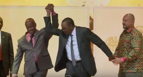President Uhuru Kenya lifts Munene Njoroge's hand during past visit to St Mary's School
