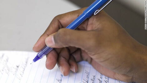 A stock image of a man writing a note