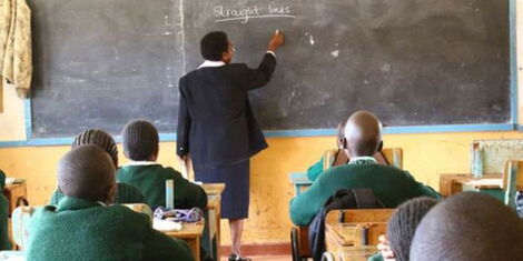A photo of a teacher and students during an ongoing class session.